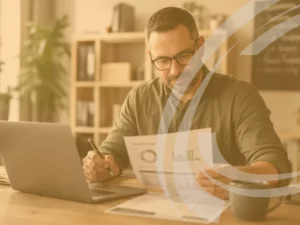 A close, well-lit shot of a small business owner reviewing figures on a laptop or printed report, calm and in control