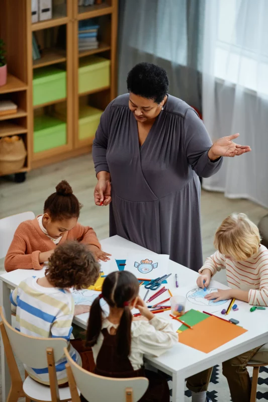 Teacher assists students with arts and crafts proj 2026 03 23 23 25 31 utc
